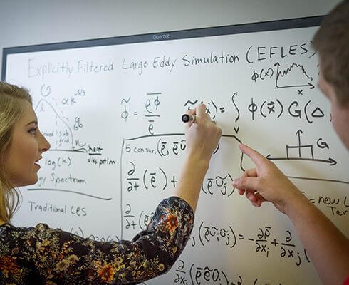 Employees writing on a board